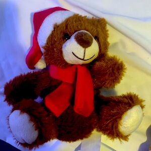 Red hat and a Santa stuffed animal and a red scarf and a brown body like a bear